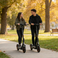 Two adults with KingSong E1 KSE electric scooters on a paved park path